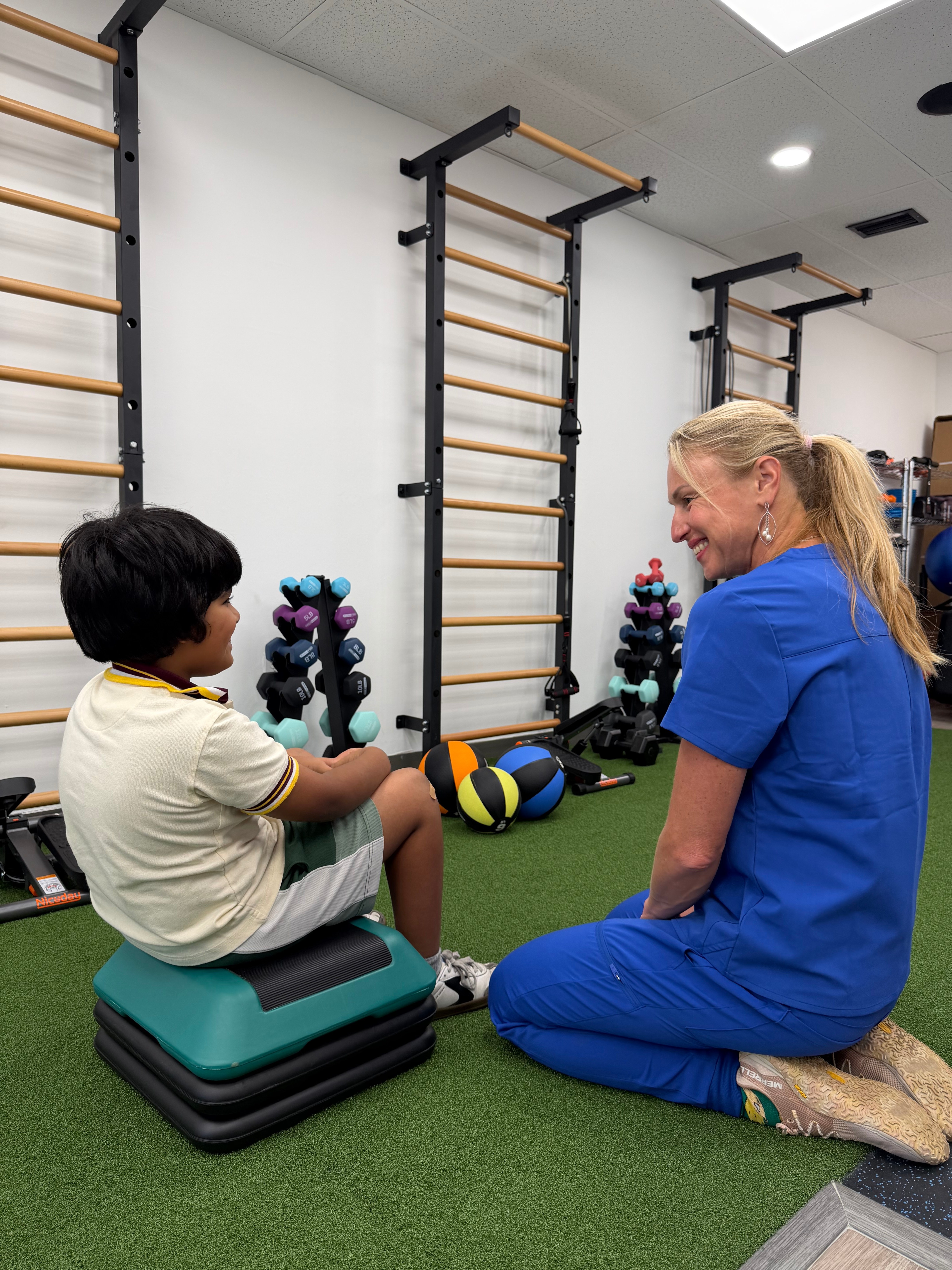 Dr. Alina working with a patient in the gym area